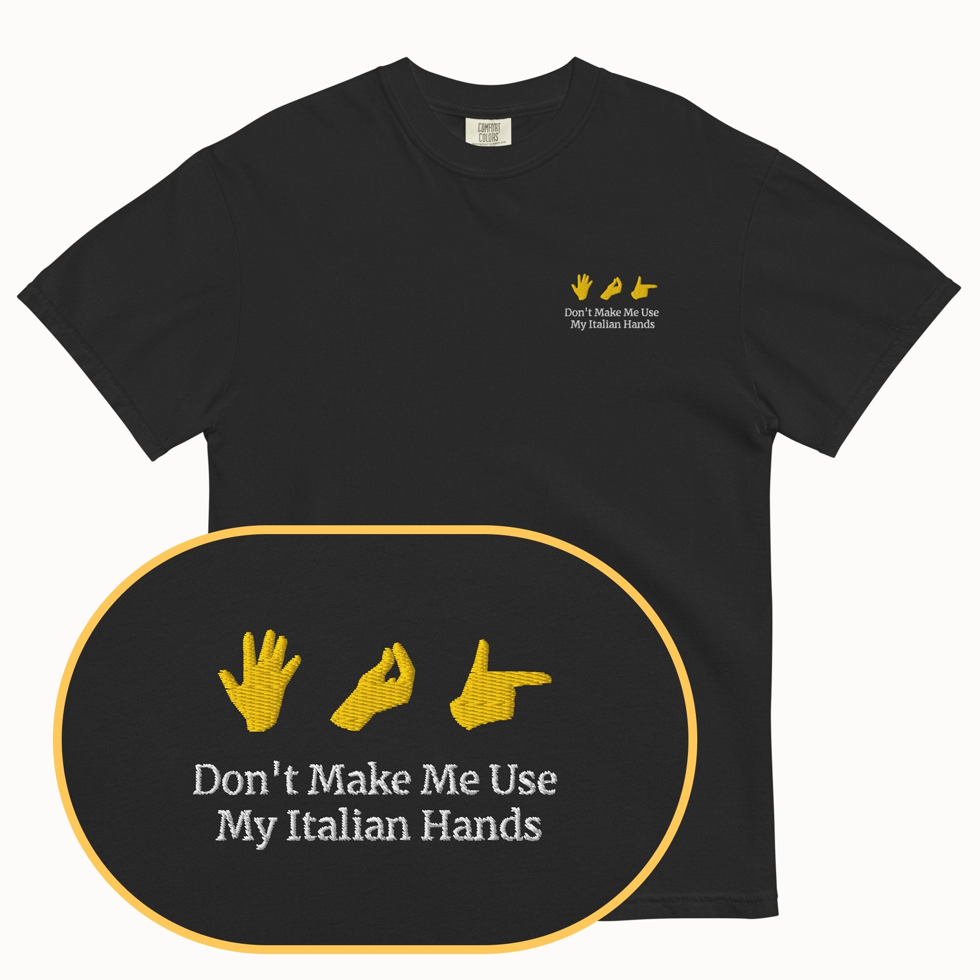 Black t-shirt with yellow graphic and text 'Don't Make Me Use My Italian Hands' on a white background
